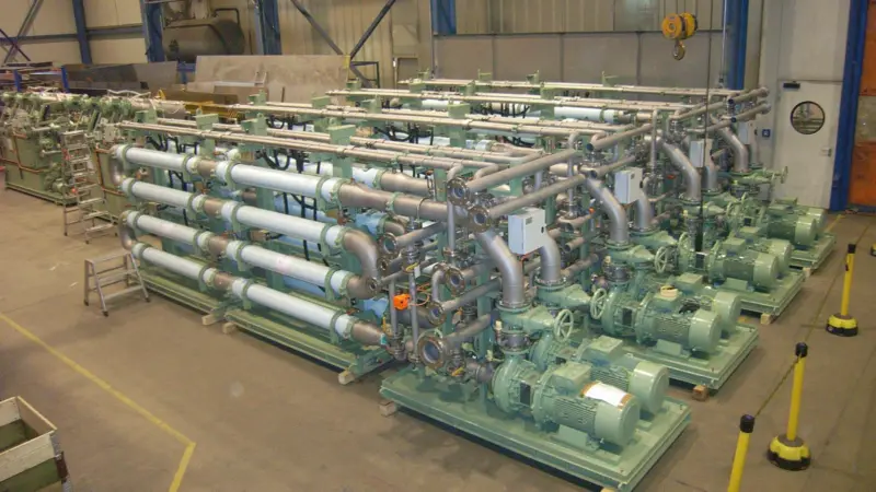 A large Hamworthy MBR system destined for a cruise ship, seen during factory inspection, showing the finished membrane skids in the foreground with the inter-stage filtration units behind