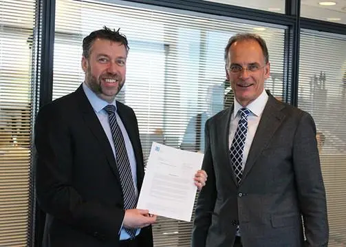 Morten Jensen, sales & marketing manager at Lloyd's Register (left) handing over the statement of fact to Ulrich Schittek, head of management services, after sales, at Maersk Tankers (right) Photo: Maersk Tankers