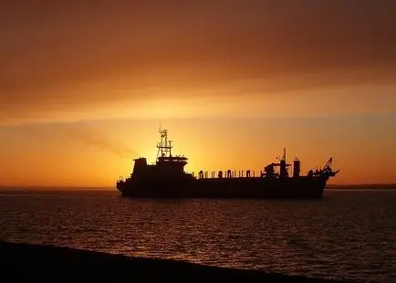 Ship at sea with setting sun behind